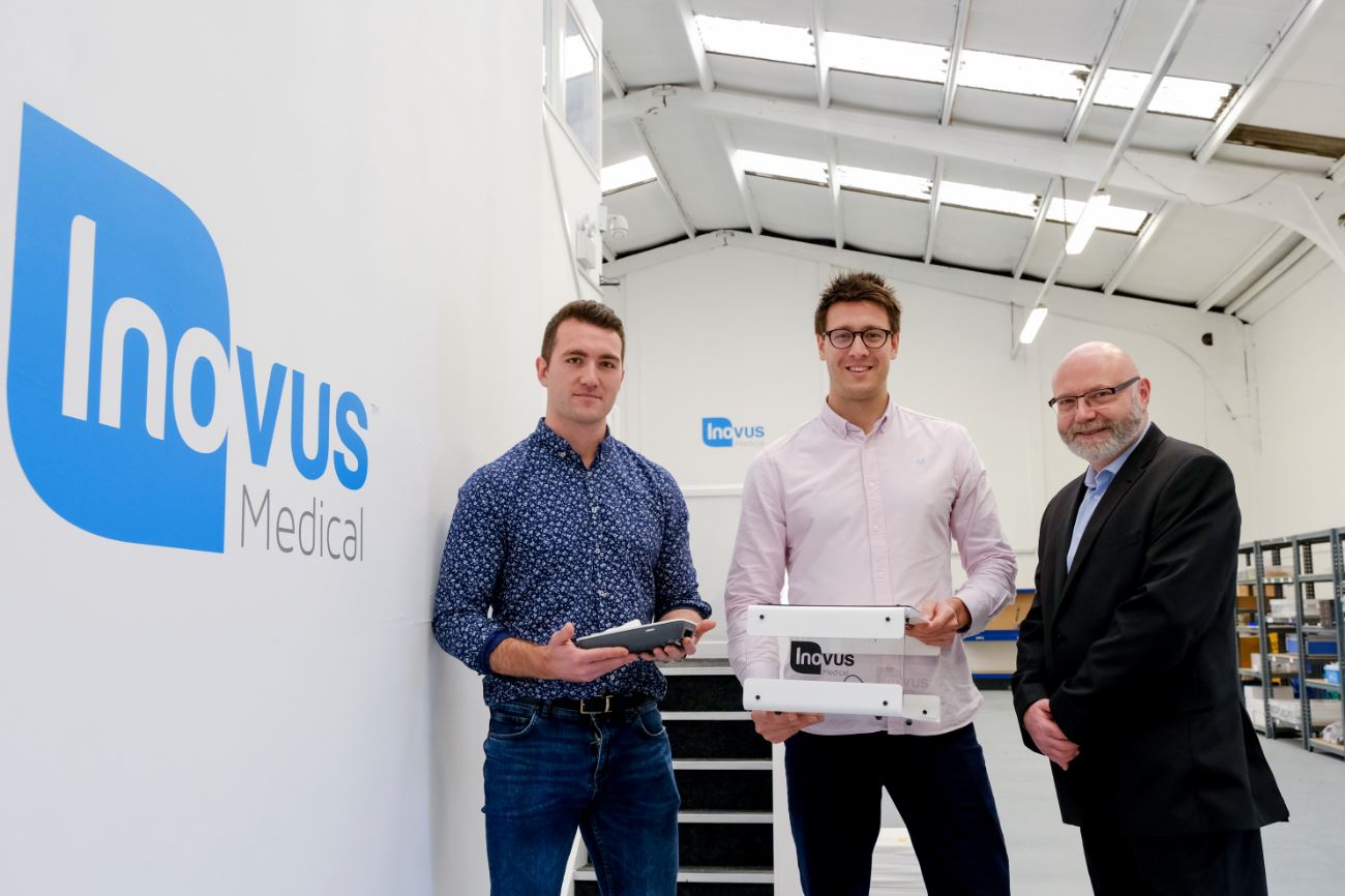 3 men from Inovus Medical stood in their warehouse holding some equipment