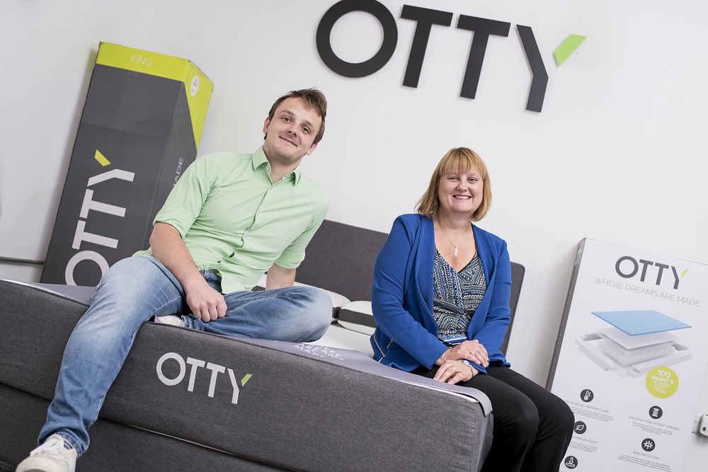 A man and a woman sat on an OTTY mattress