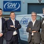 4 men in suits stood in front of a GW van