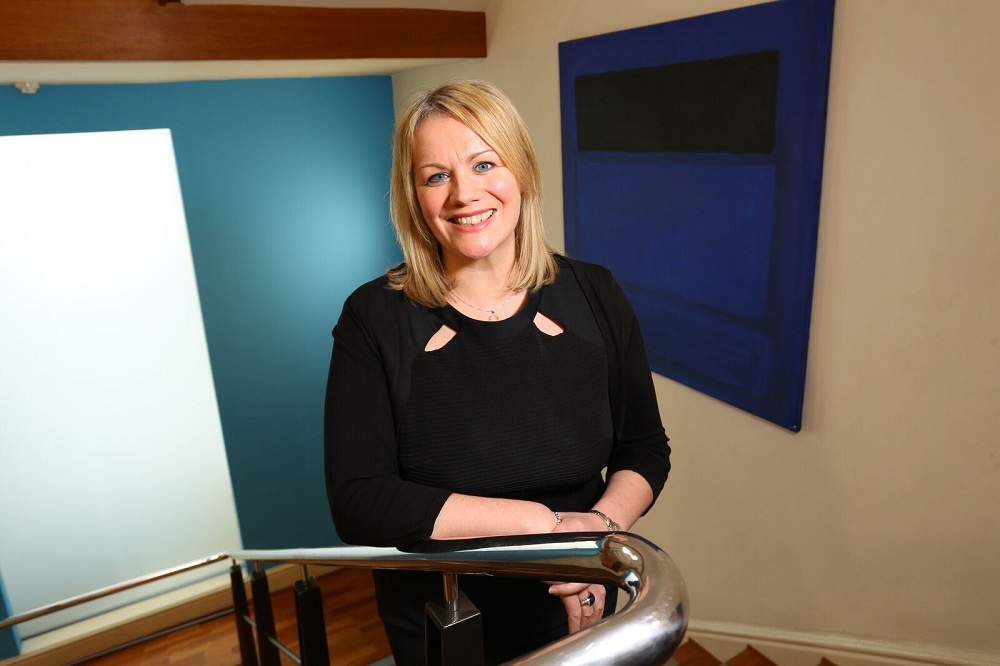Joanne Whitfield, Fund Director at FW Capital stood on the stairs in an office building