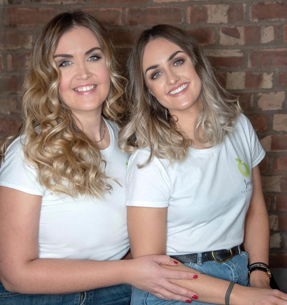 2 women from Fresh Perspective Resourcing sat in front of a brick wall smiling