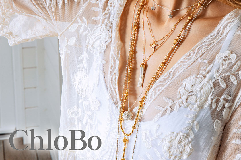 A close up of a woman's modelling for ChloBo who is wearing a lace cardigan and necklaces