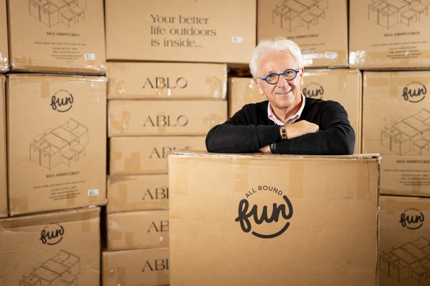 A man standing in front of All Round Fun boxes